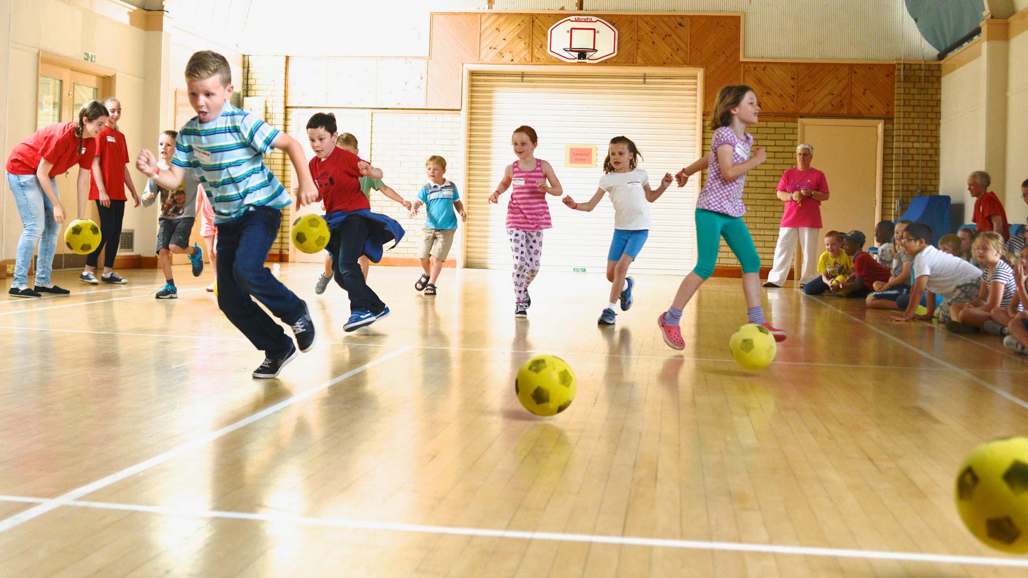 Children playing football in church hall