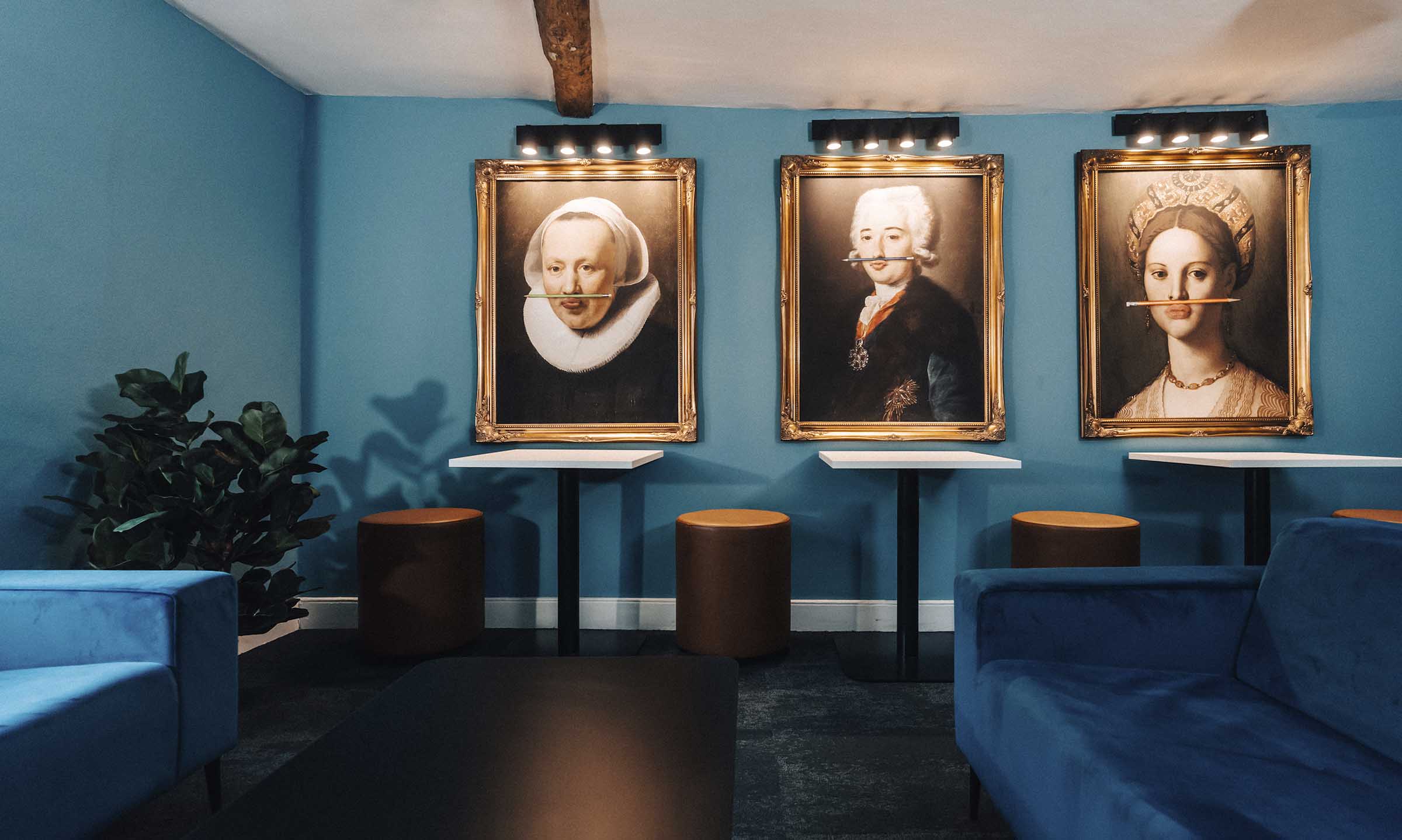 Three paintings in gold frames on wall