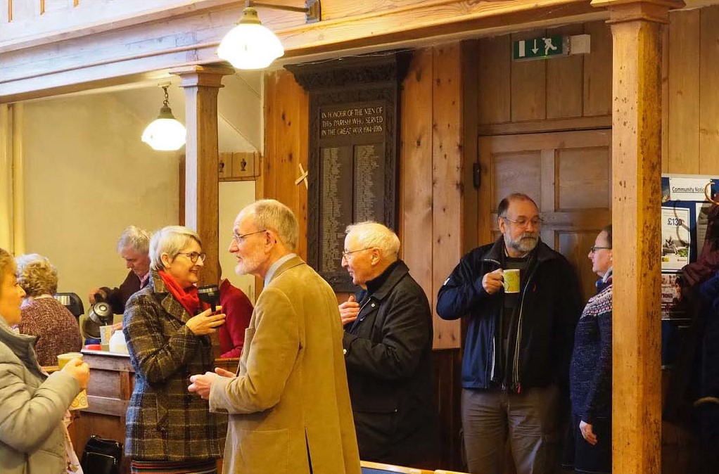 Group of people chatting over coffee in church hall